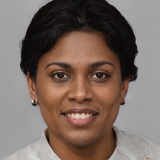 Joyful black young-adult female with short  black hair and brown eyes