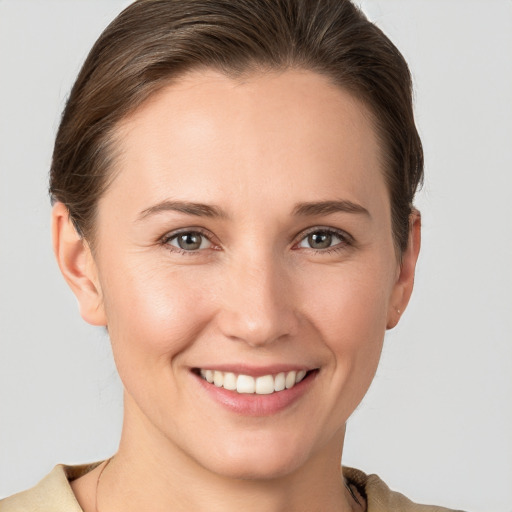 Joyful white young-adult female with short  brown hair and grey eyes