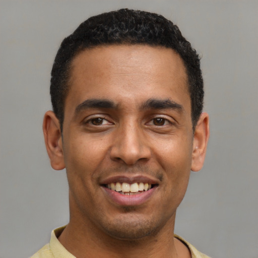 Joyful latino young-adult male with short  black hair and brown eyes