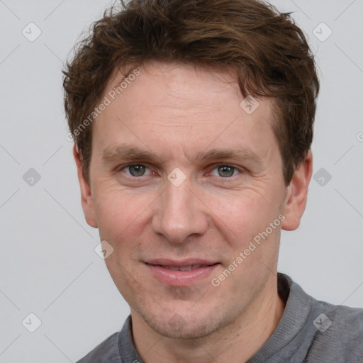 Joyful white adult male with short  brown hair and grey eyes