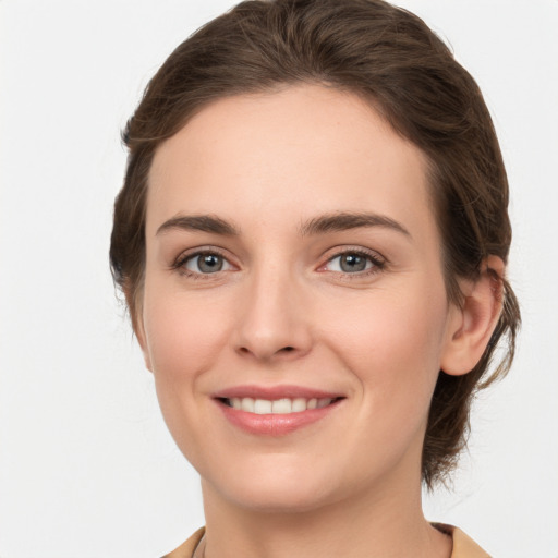 Joyful white young-adult female with medium  brown hair and grey eyes