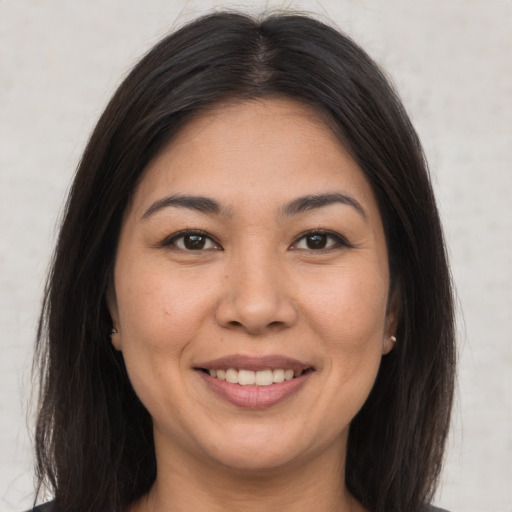 Joyful latino young-adult female with long  brown hair and brown eyes
