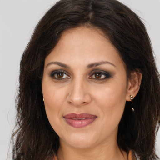 Joyful latino adult female with long  brown hair and brown eyes