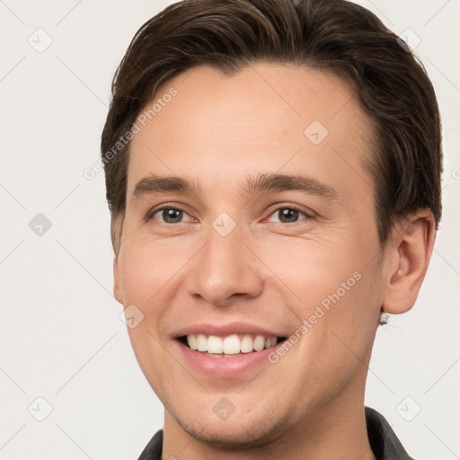 Joyful white young-adult male with short  brown hair and grey eyes