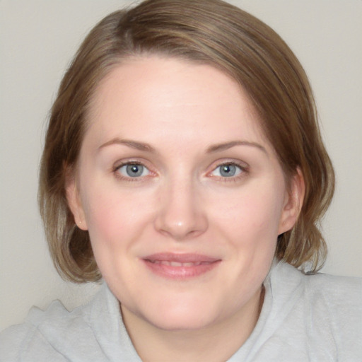 Joyful white young-adult female with medium  brown hair and blue eyes