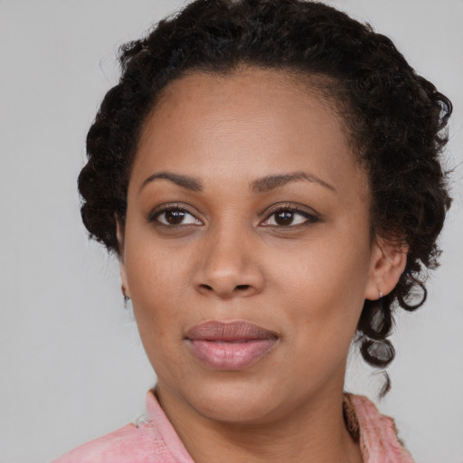 Joyful black young-adult female with medium  brown hair and brown eyes