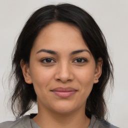 Joyful latino young-adult female with medium  brown hair and brown eyes