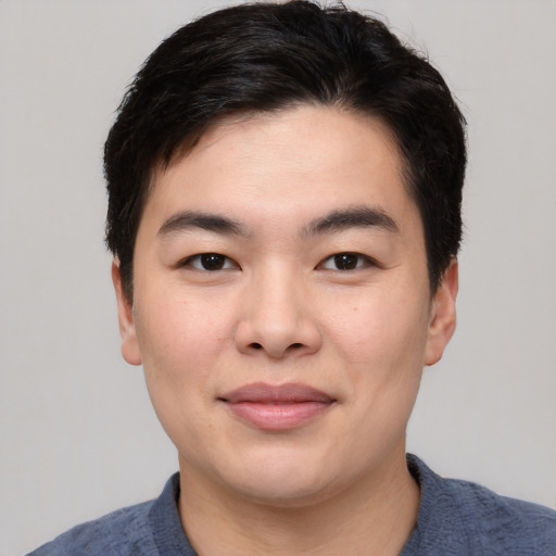 Joyful asian young-adult male with short  black hair and brown eyes