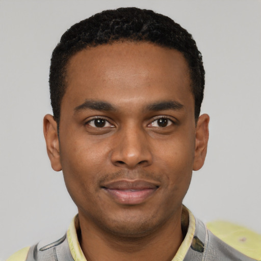 Joyful black young-adult male with short  black hair and brown eyes