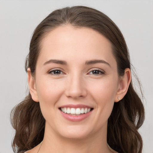 Joyful white young-adult female with long  brown hair and grey eyes