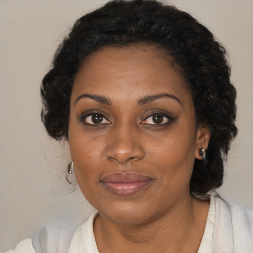 Joyful black adult female with medium  brown hair and brown eyes