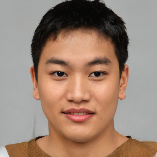 Joyful asian young-adult male with short  brown hair and brown eyes