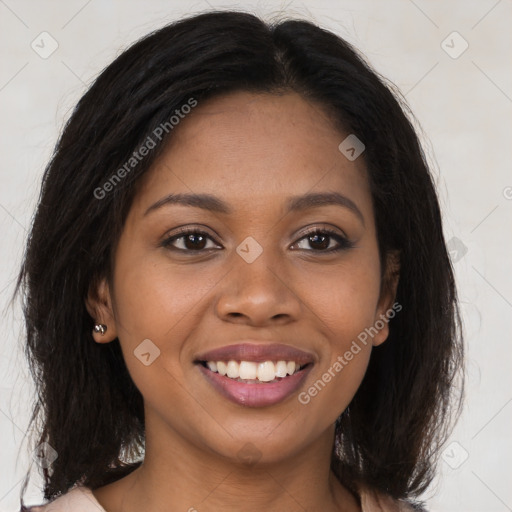 Joyful black young-adult female with long  brown hair and brown eyes