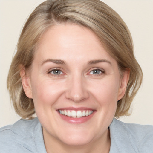 Joyful white adult female with medium  brown hair and blue eyes