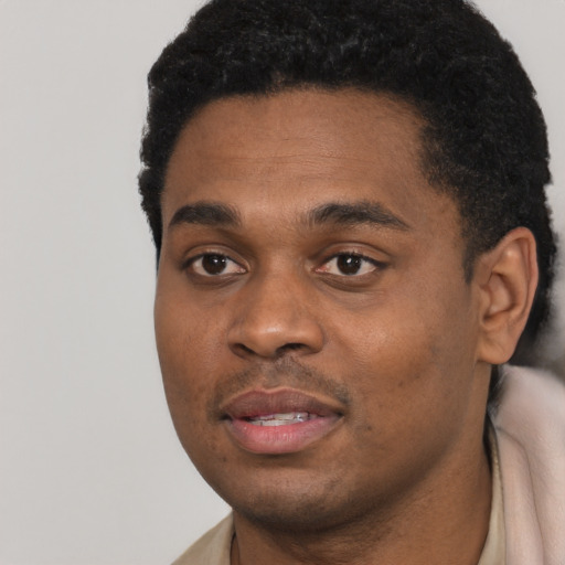 Joyful black young-adult male with short  black hair and brown eyes