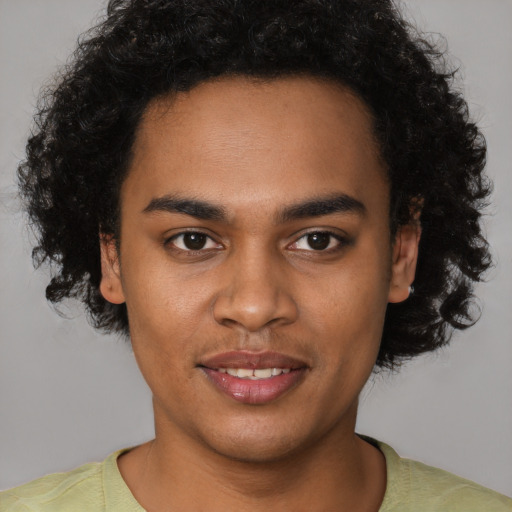 Joyful black young-adult male with short  brown hair and brown eyes