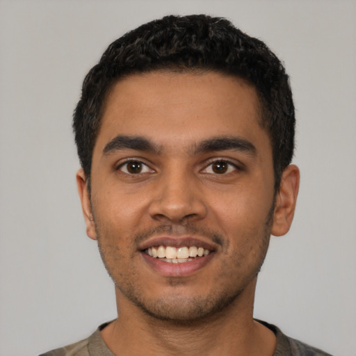 Joyful latino young-adult male with short  black hair and brown eyes