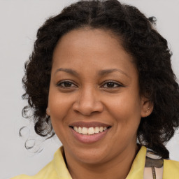 Joyful black adult female with medium  brown hair and brown eyes