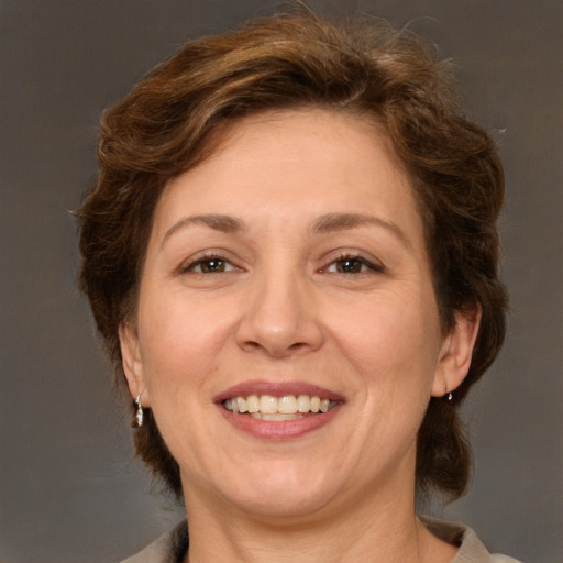 Joyful white adult female with medium  brown hair and green eyes