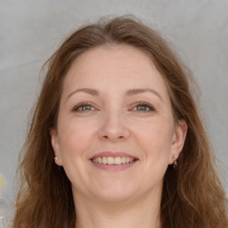 Joyful white adult female with long  brown hair and grey eyes