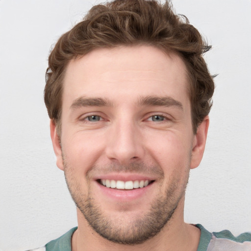 Joyful white young-adult male with short  brown hair and blue eyes