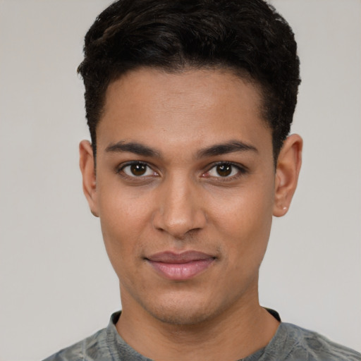 Joyful latino young-adult male with short  black hair and brown eyes