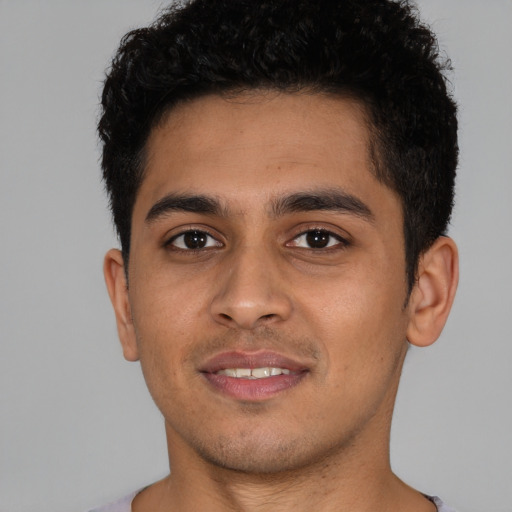 Joyful latino young-adult male with short  brown hair and brown eyes