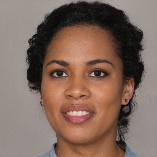 Joyful black young-adult female with long  black hair and brown eyes