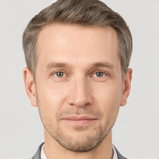 Joyful white adult male with short  brown hair and grey eyes