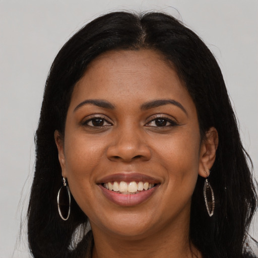 Joyful black young-adult female with long  brown hair and brown eyes