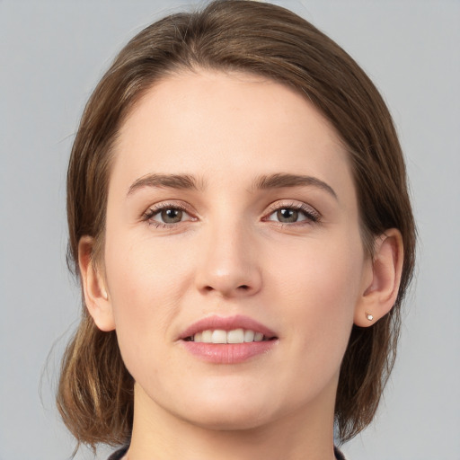 Joyful white young-adult female with medium  brown hair and grey eyes