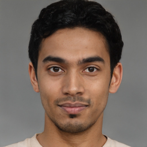 Joyful latino young-adult male with short  black hair and brown eyes