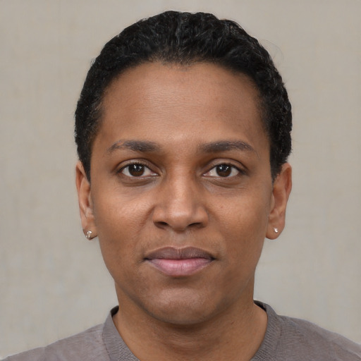 Joyful black young-adult female with short  black hair and brown eyes