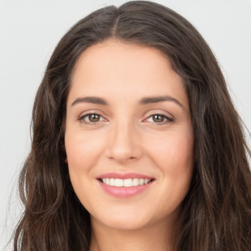 Joyful white young-adult female with long  brown hair and brown eyes