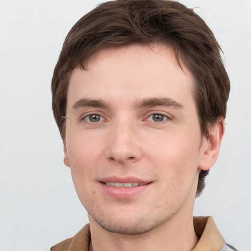 Joyful white young-adult male with short  brown hair and grey eyes