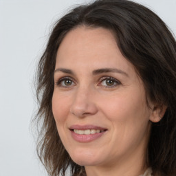 Joyful white adult female with long  brown hair and brown eyes