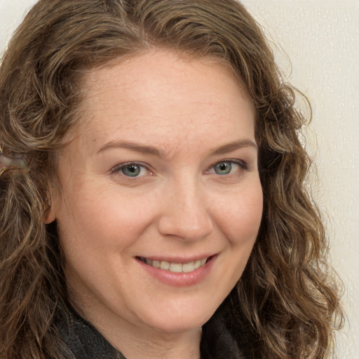 Joyful white adult female with long  brown hair and green eyes