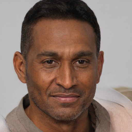 Joyful black adult male with short  brown hair and brown eyes