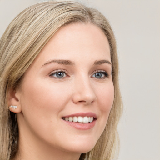 Joyful white young-adult female with long  brown hair and blue eyes