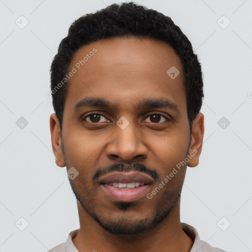 Joyful black young-adult male with short  black hair and brown eyes
