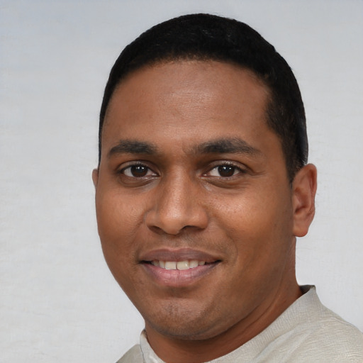 Joyful black young-adult male with short  black hair and brown eyes