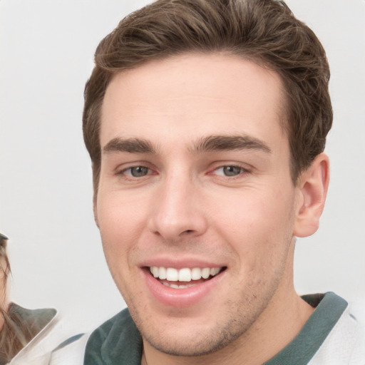 Joyful white young-adult male with short  brown hair and grey eyes