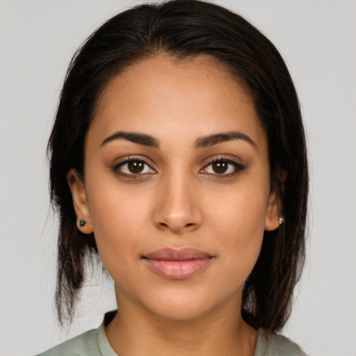 Joyful latino young-adult female with medium  brown hair and brown eyes