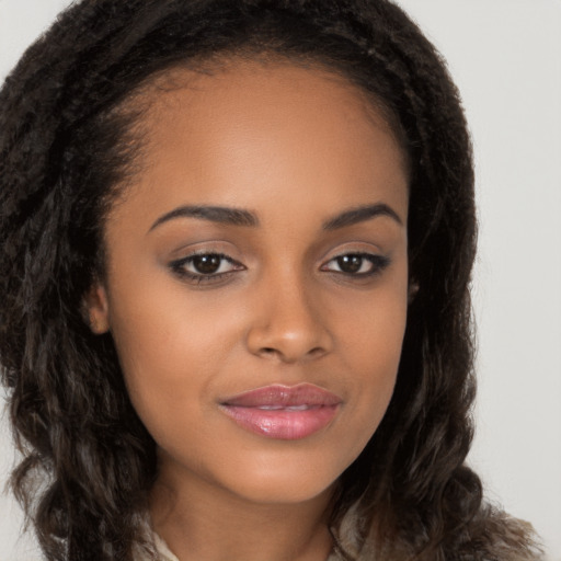 Joyful black young-adult female with long  brown hair and brown eyes