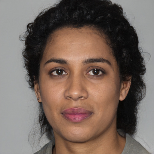 Joyful black young-adult female with medium  black hair and brown eyes