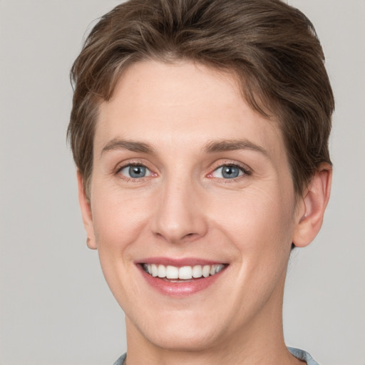 Joyful white young-adult female with short  brown hair and grey eyes