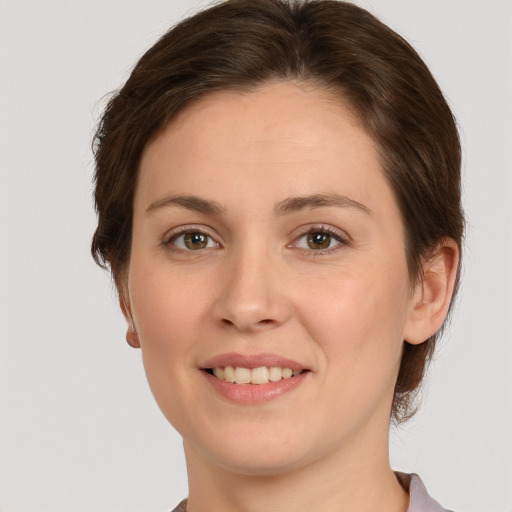 Joyful white young-adult female with medium  brown hair and green eyes