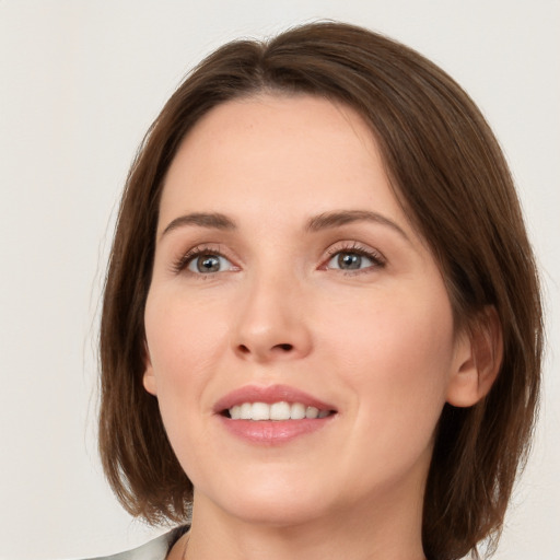 Joyful white young-adult female with medium  brown hair and grey eyes