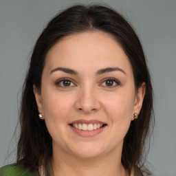 Joyful white young-adult female with long  brown hair and brown eyes