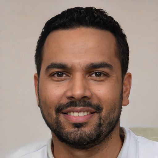 Joyful latino young-adult male with short  black hair and brown eyes